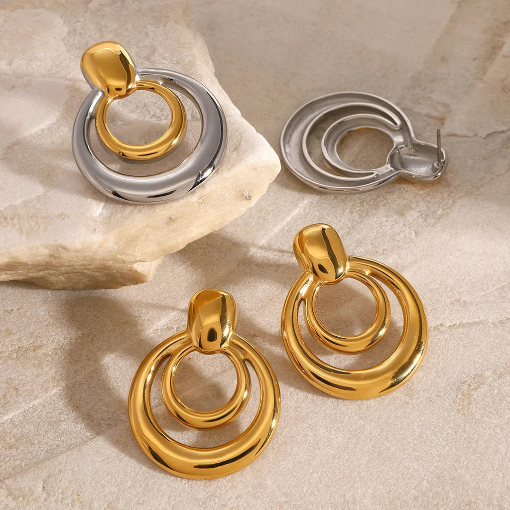 Round golden double layer hollow stud earrings for women with a geometric design.