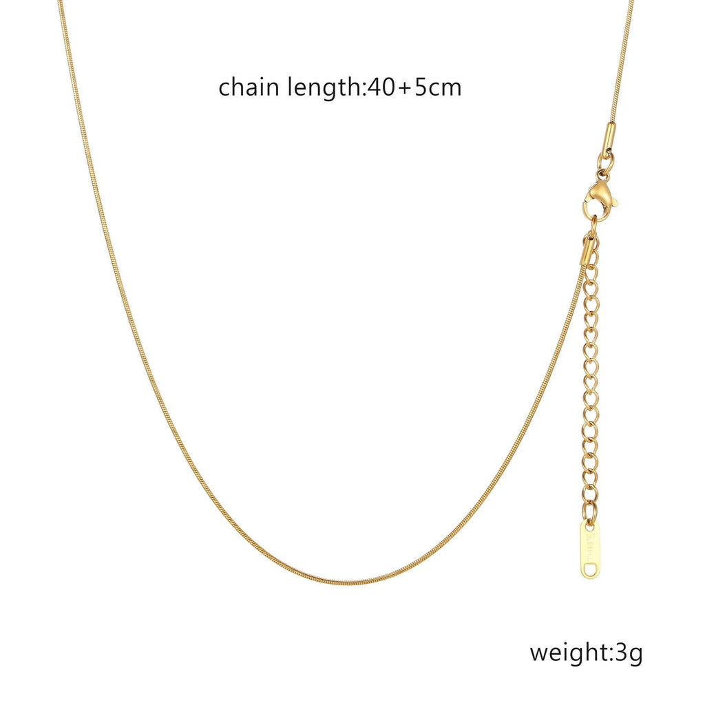 Women's stainless steel necklace with 18K gold hollow round pendant and O-link chain on neutral background