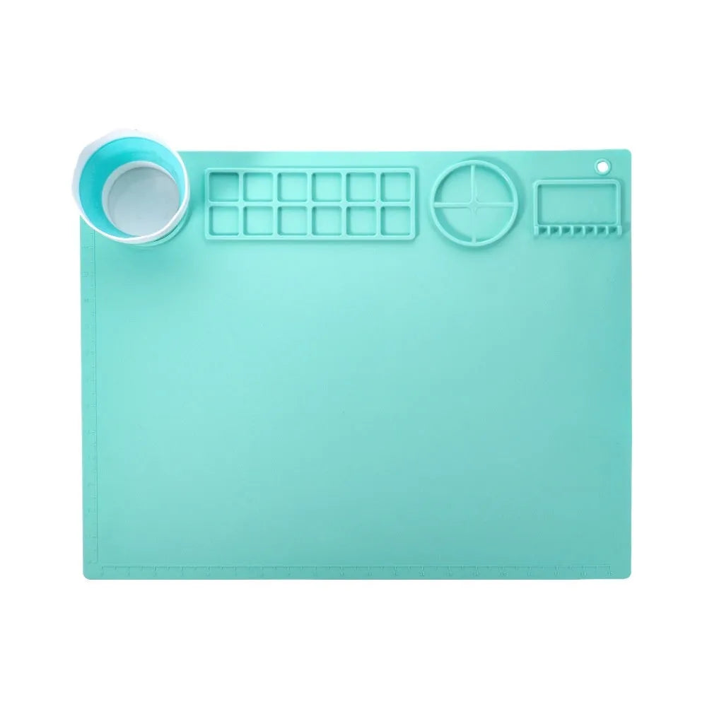Light blue silicone painting mat with two moulded bowls for artists, size 50cm by 40cm.