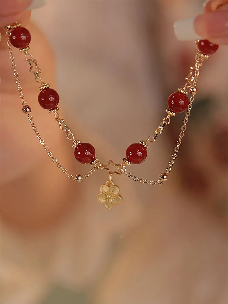 Women's double layer bracelet made from natural red agate with peach blossom decorations.