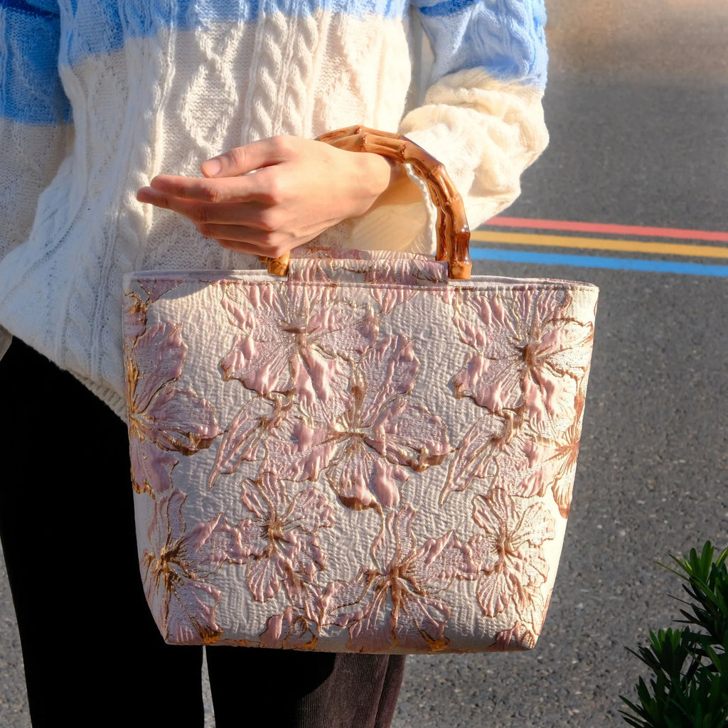 Women's light blue canvas shoulder bag with bronzing flower detail showing horizontal square shape and double straps