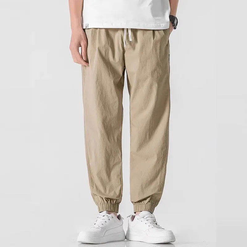 Men's loose cuffed cargo pants in black polyester fabric with cuffed hem and relaxed fit