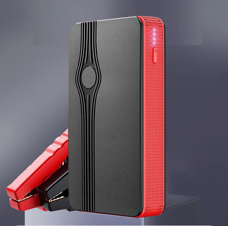 Red K4-E portable car jump starter and power bank with data cable, showing compact size for vehicle glovebox storage.