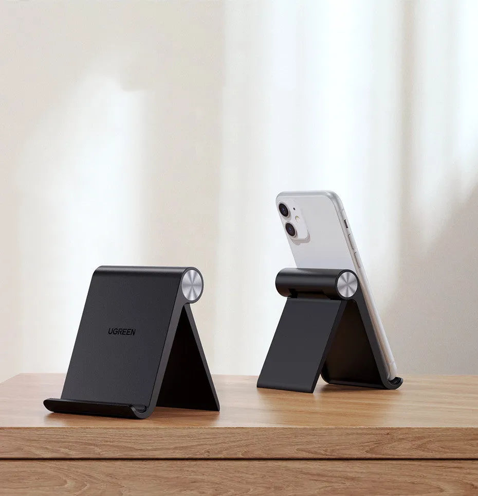 UGREEN Lazy Bracket portable phone holder in black on a desk, holding a mobile phone.