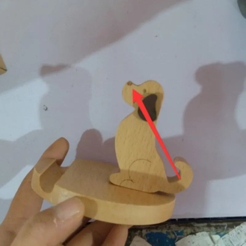 Beech wood and resin lazy bracket mobile phone holder in an animal design style on a desk.