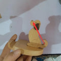 Beech wood and resin lazy bracket mobile phone holder in an animal design style on a desk.