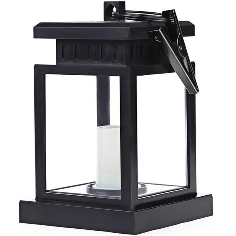 Solar LED candle light with black plastic shade, monocrystalline panel, and warm white illumination on garden path