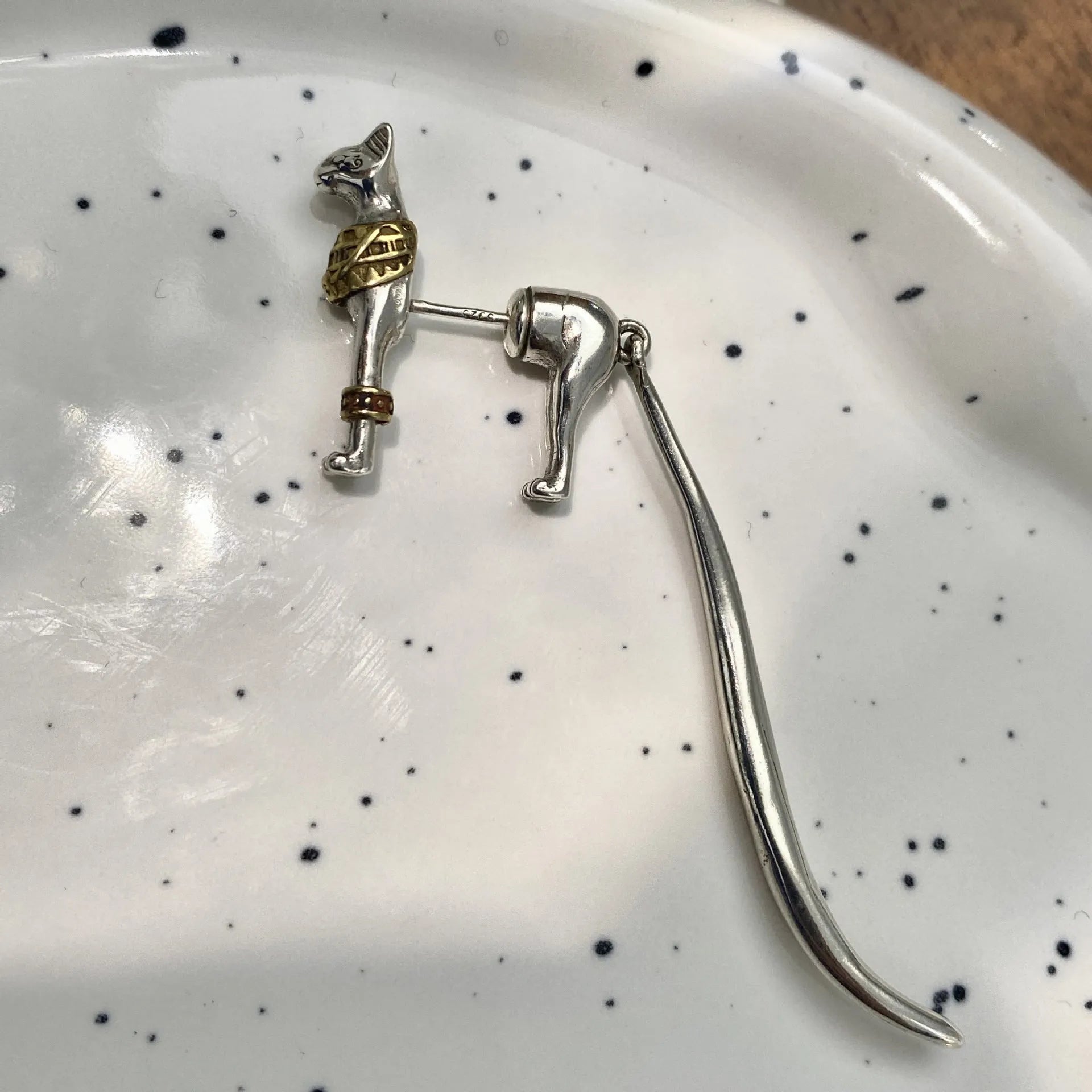Single copper earring with pharaoh cat shape, gold and silver two-tone copper plated finish, colour separation design