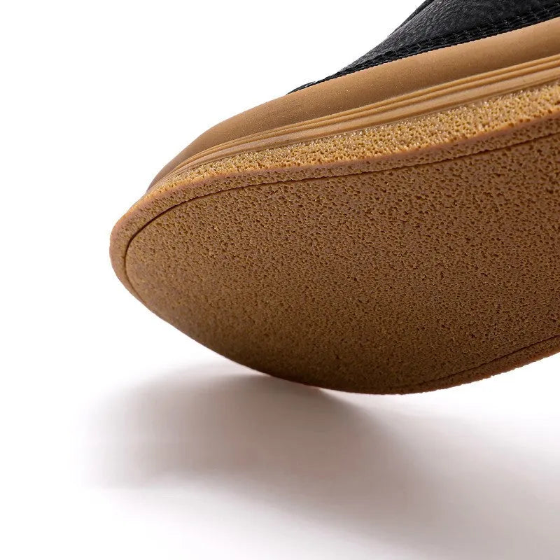 Men's black leather casual shoes with a round toe and white rubber sole on a plain background.