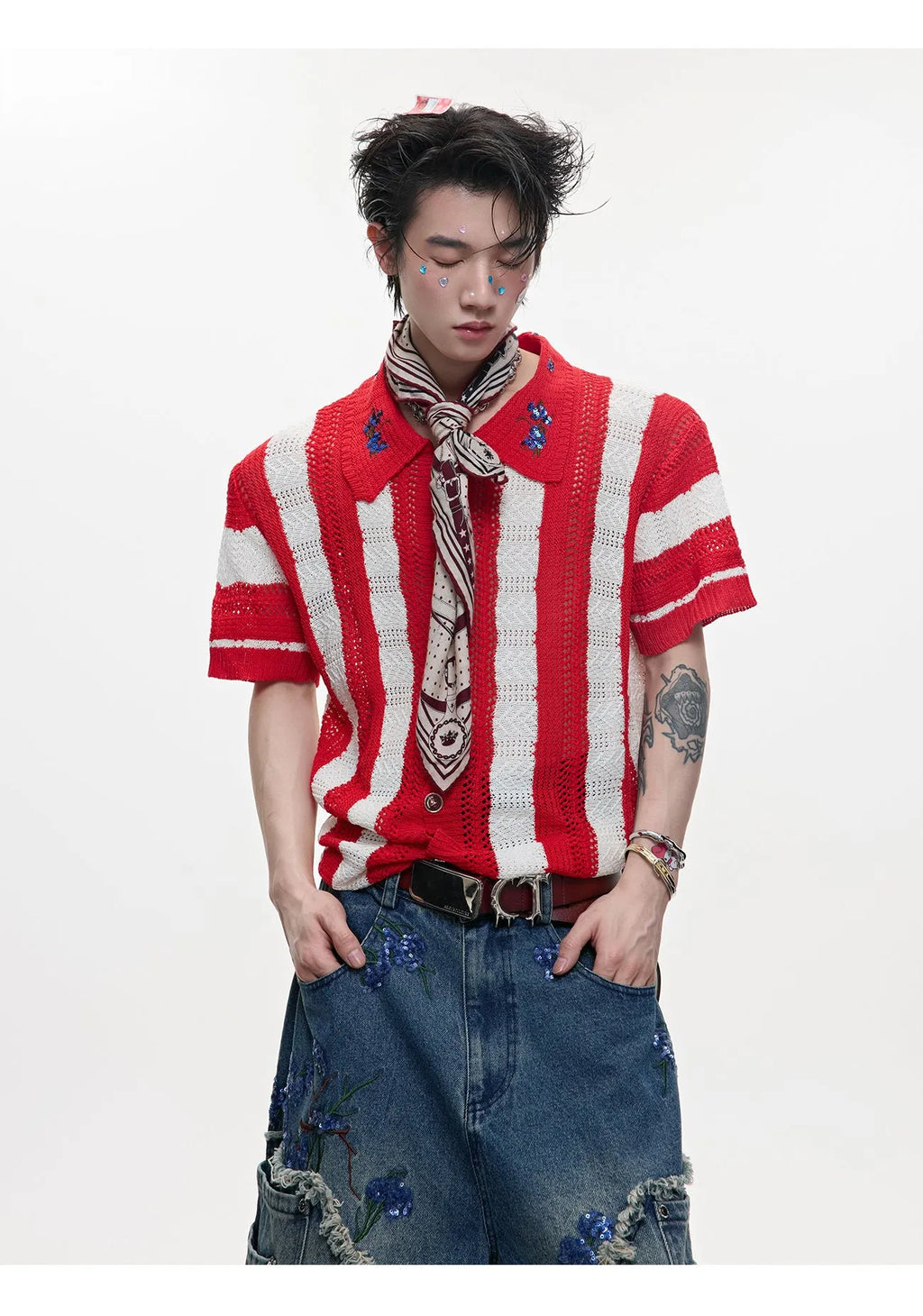 Man wearing a red and black patchwork striped retro knitted short-sleeved shirt in a loose fit.