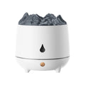 White volcano-shaped ultrasonic humidifier with USB cable on a wooden desk.