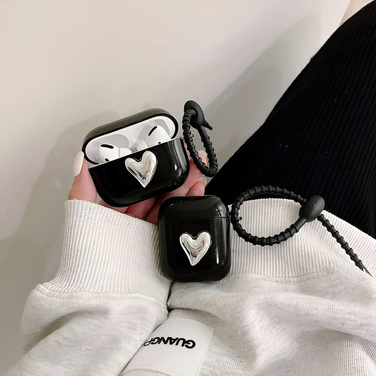 Black earphone sleeve with electroplated love heart design for AirPods case showing TPU back cover and black cord