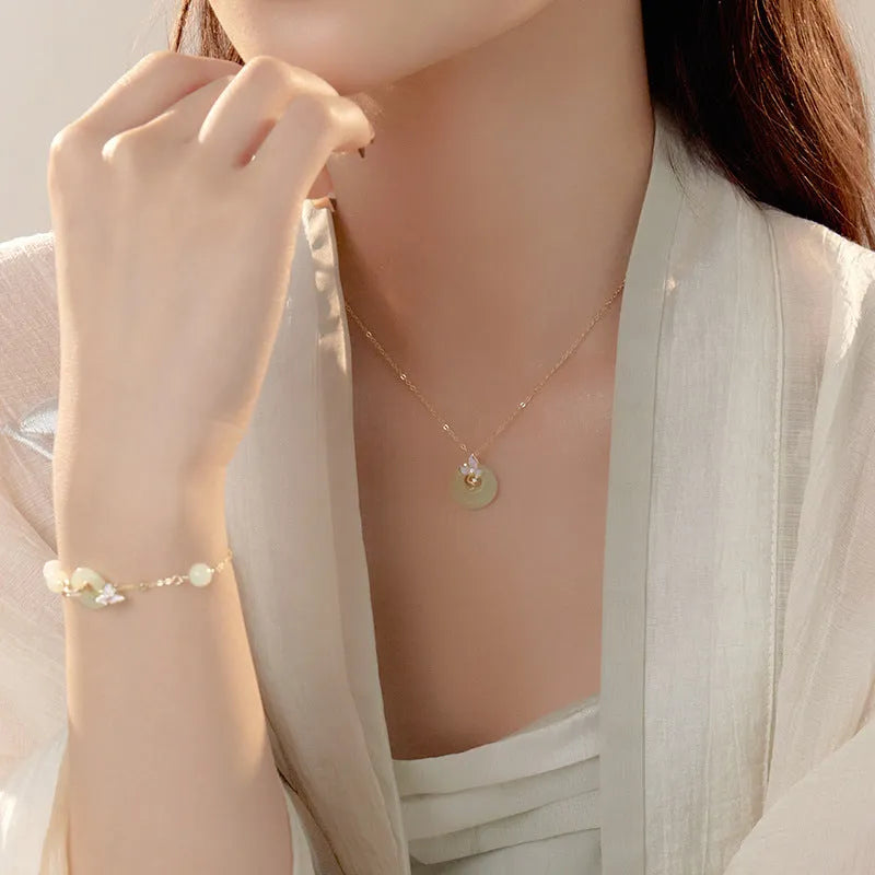 Sterling silver orchid necklace on a model, showing the floral pendant and peace buckle clasp.