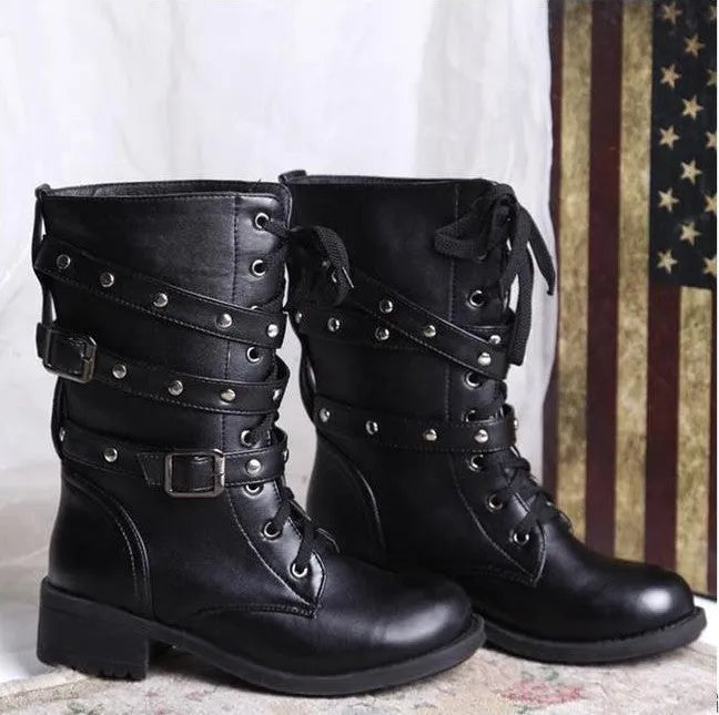 Women's black Martin motorcycle boots with low heel, lace-up front, round toe, and rivet and belt buckle detailing