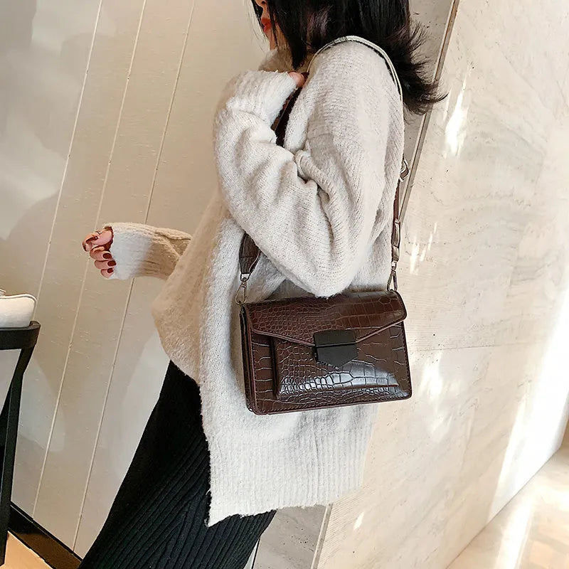 Vintage PU leather crossbody bag in black, shown with a mobile phone and wallet inside