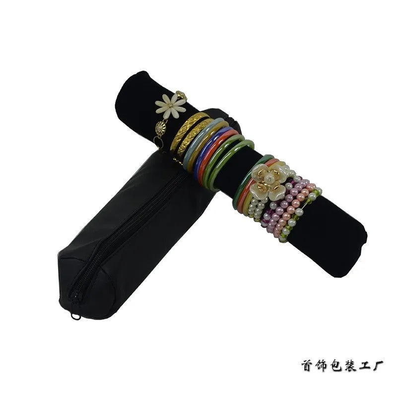 Portable bracelet watch storage bag in black leather with black bracelet stick on a flat surface