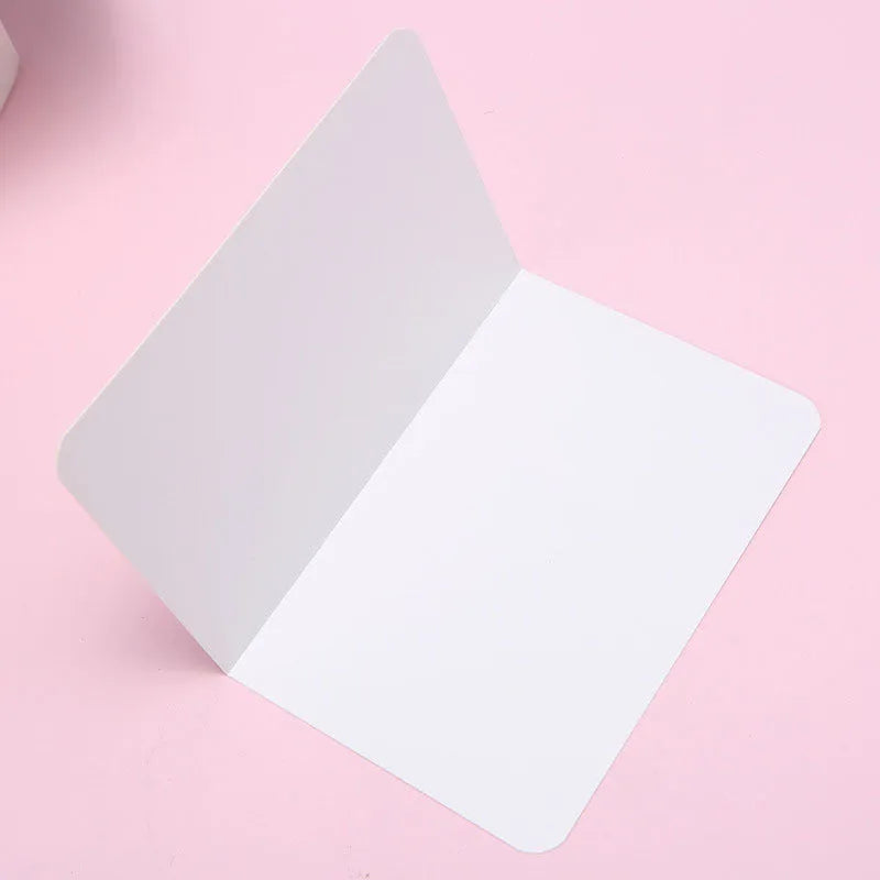 Pack of 100 blank folded kraft greeting cards in 10x15cm size, showing black, brown, and white colour options.