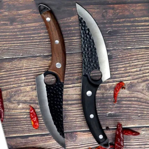 Curved boning butcher knife with hammer-pattern blade and brown leather sheath on a cutting board.