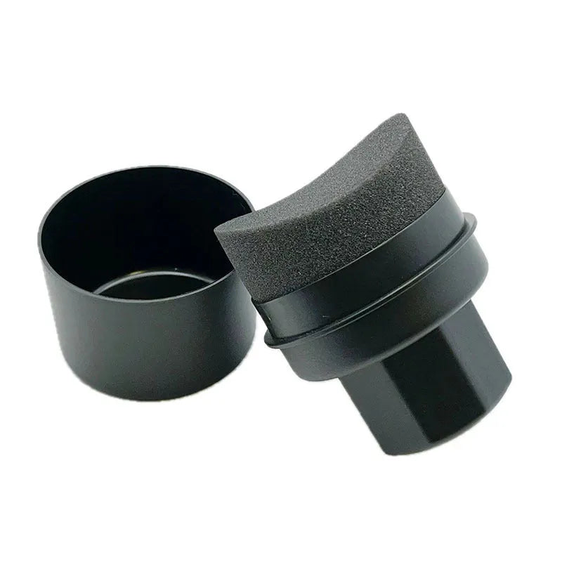 Black and red hand-held car tyre polishing sponge brushes with lids on a workbench.