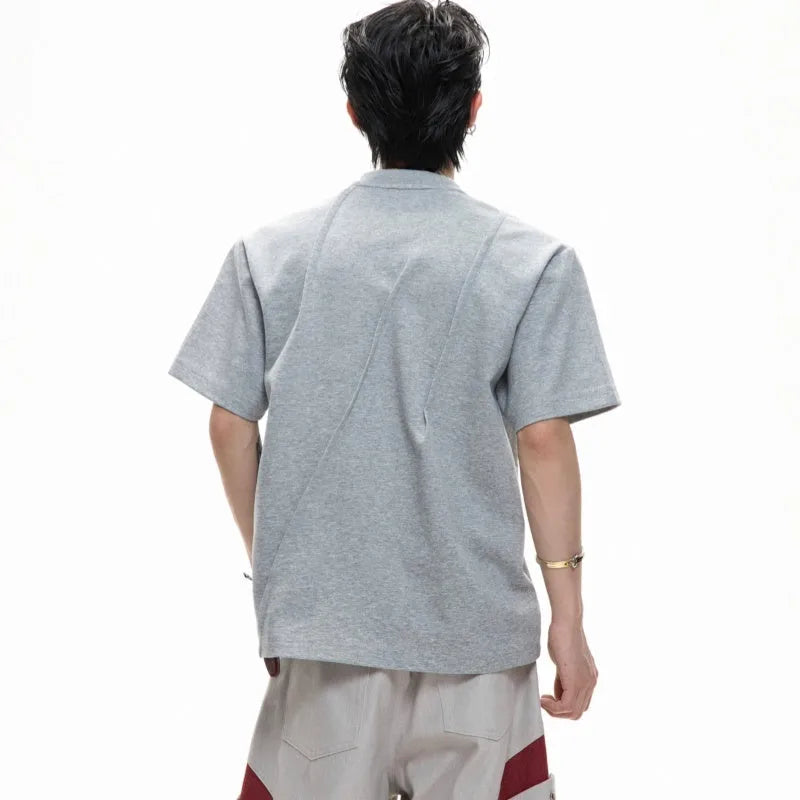 Men's loose grey cotton T-shirt with round neck and asymmetric stitching on the front.