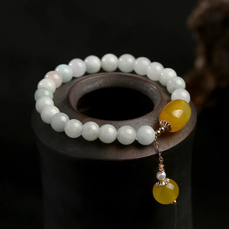 Women's ethnic style geometric bracelet with hanging agate tassel and 14K gilded details.