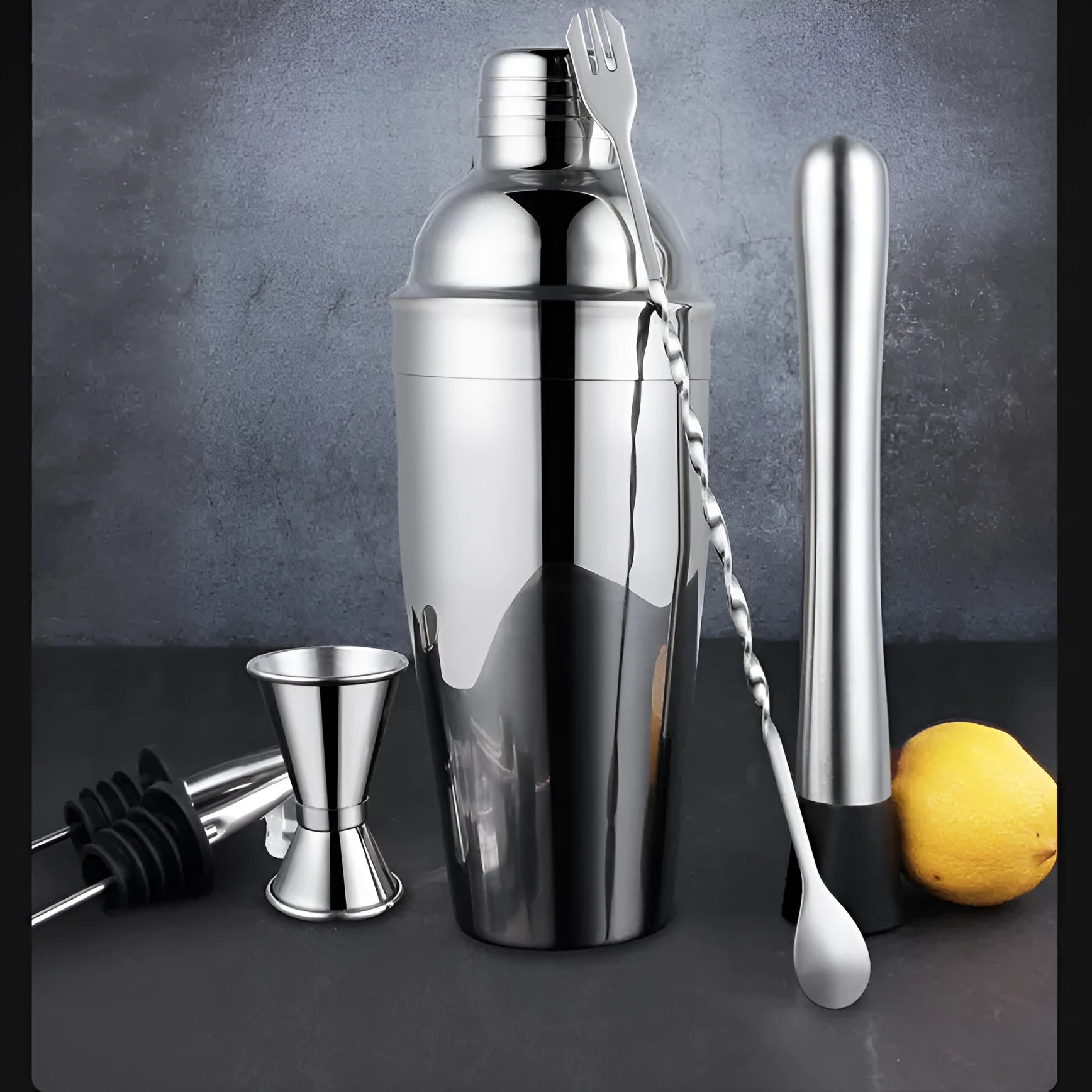 23-piece stainless steel cocktail set with shaker, jiggers, strainer and bar tools on a countertop.