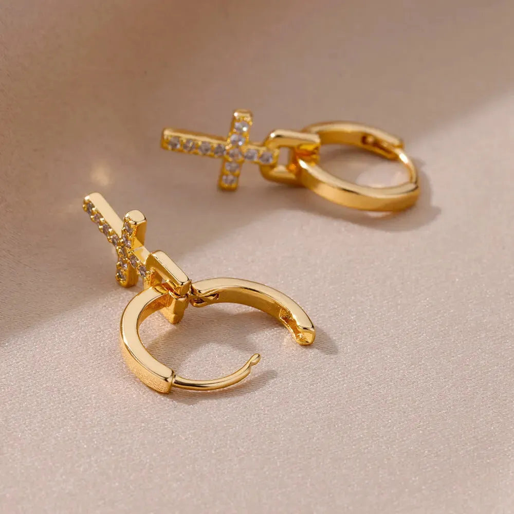 Cross stud earrings with 18K gold plating and clear zircon stone on a white background