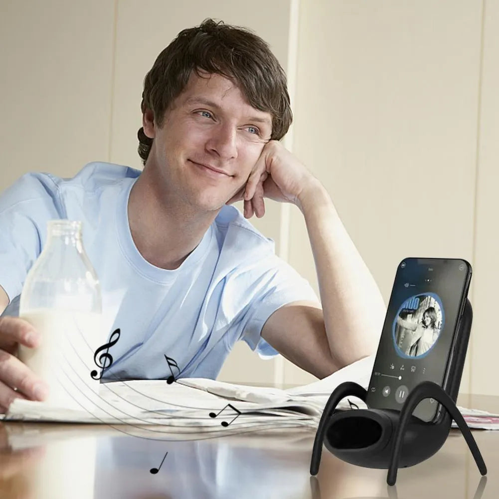 White chair-shaped wireless charging phone stand charging a smartphone on a desk