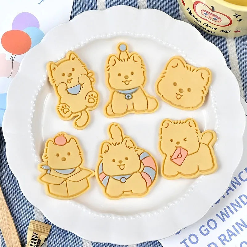 A 3D plastic biscuit mould showing raised puppy head, birthday hat, and dog cartoon designs.
