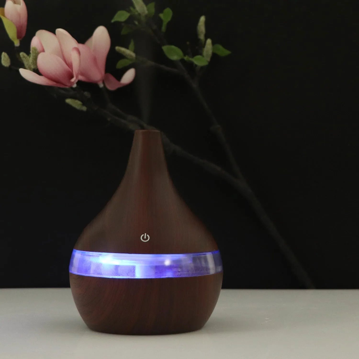 Columnar USB mini air purifier and humidifier in light wood grain finish on a desk.