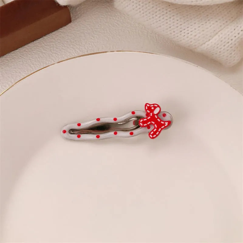Red love heart-shaped plastic hair clip with retro dots and a willow leaf silhouette on a white background.