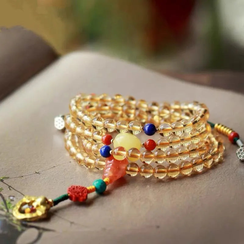 Yellow natural citrine bracelet with 1mm beads and filament accessory details on a wrist.