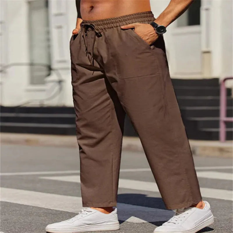 Men's straight-leg linen trousers in a solid colour, showing the elasticated mid waist and long leg.