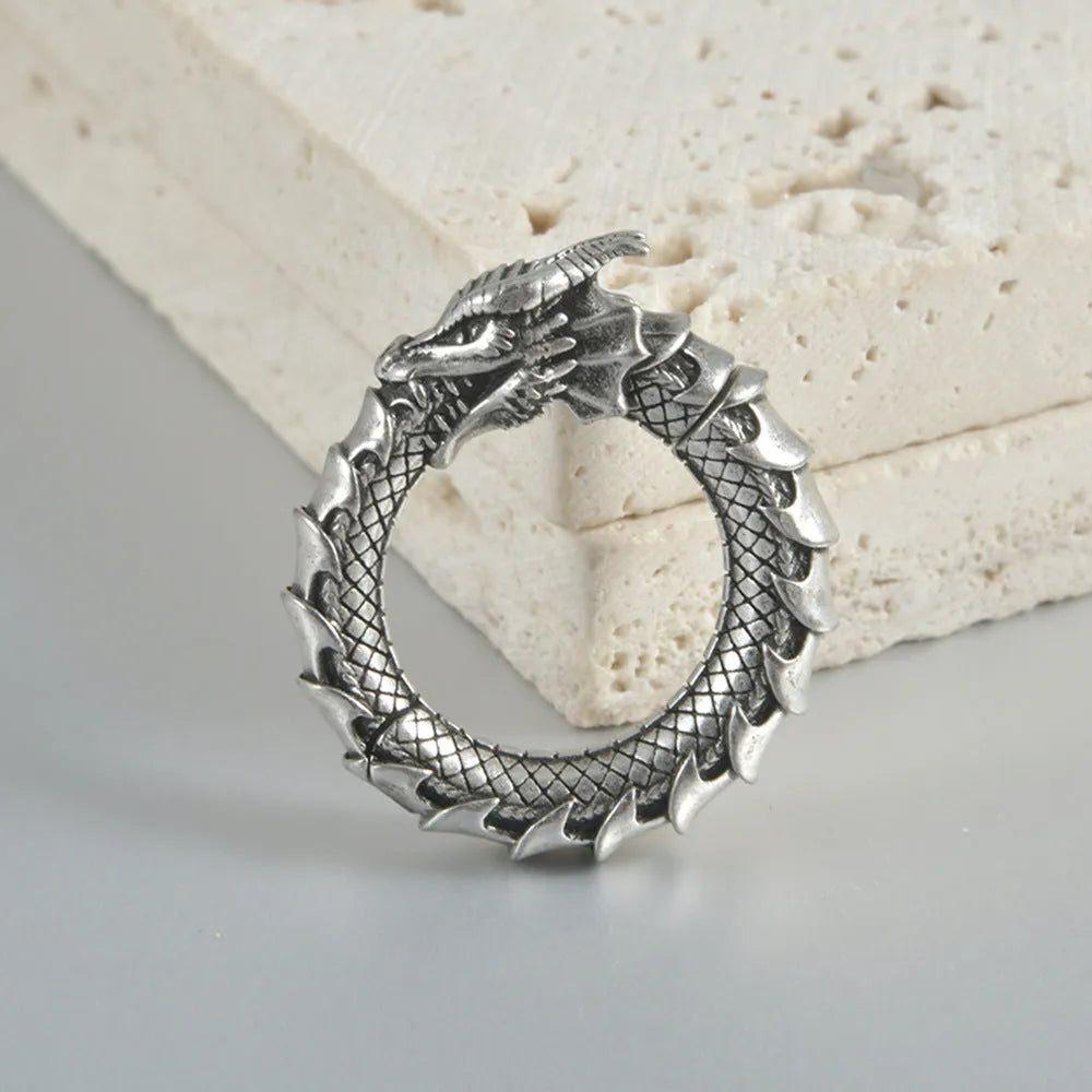 Large hollow out stainless steel earrings with an antique silver dragon design.