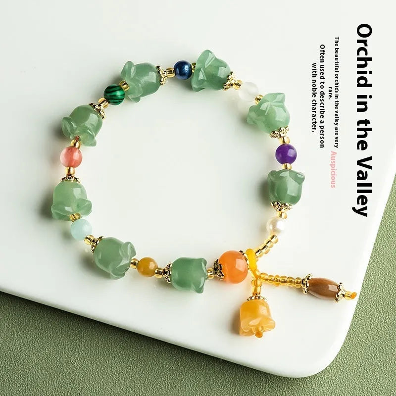 Natural Jinsi Jade bracelet with carved orchid beads on a wrist.
