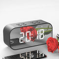 Wireless Bluetooth speaker with LED clock display showing time, black colour, compact ABS body on a desk