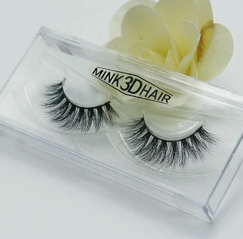 Pair of faux mink eyelashes with long tail and cotton stem against white background