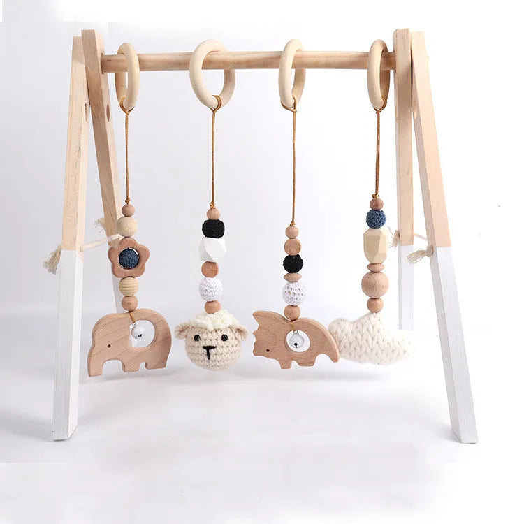 Beech wood baby rattle with animal pendants in orange, 28cm length, on white background