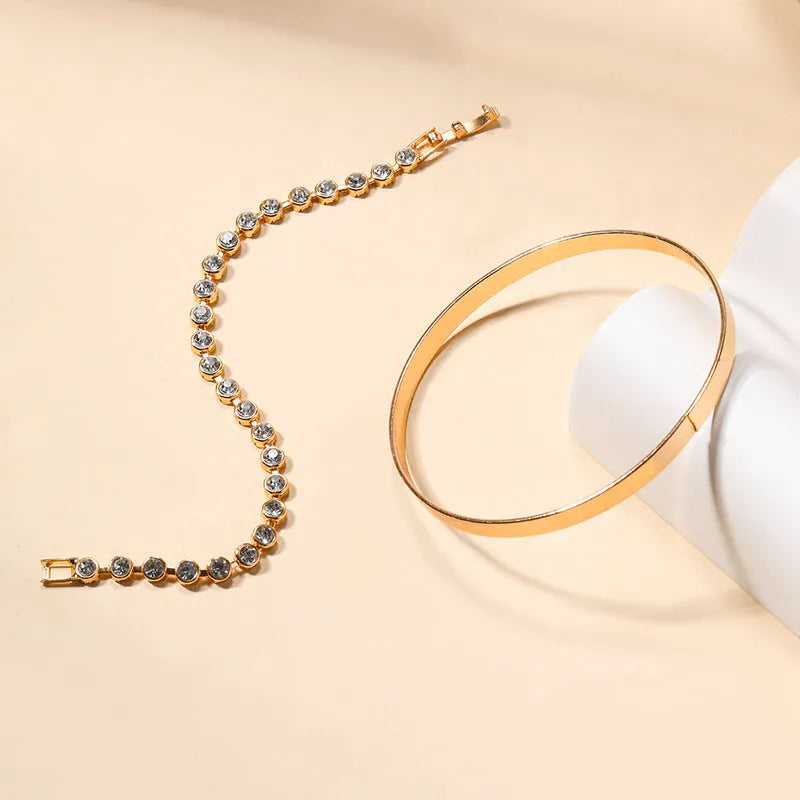 Two vintage drop-shaped geometric bracelets in gold and silver, side by side