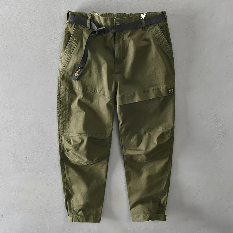 Man wearing khaki-coloured casual cotton overalls with a loose fit and mid-waist design.