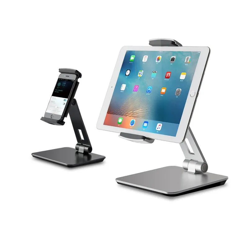 Silver foldable aluminium phone and tablet stand on a desk, holding a tablet at an angle.