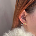 A pair of large pearl stud earrings with a geometric silver setting and an eight-point star detail.