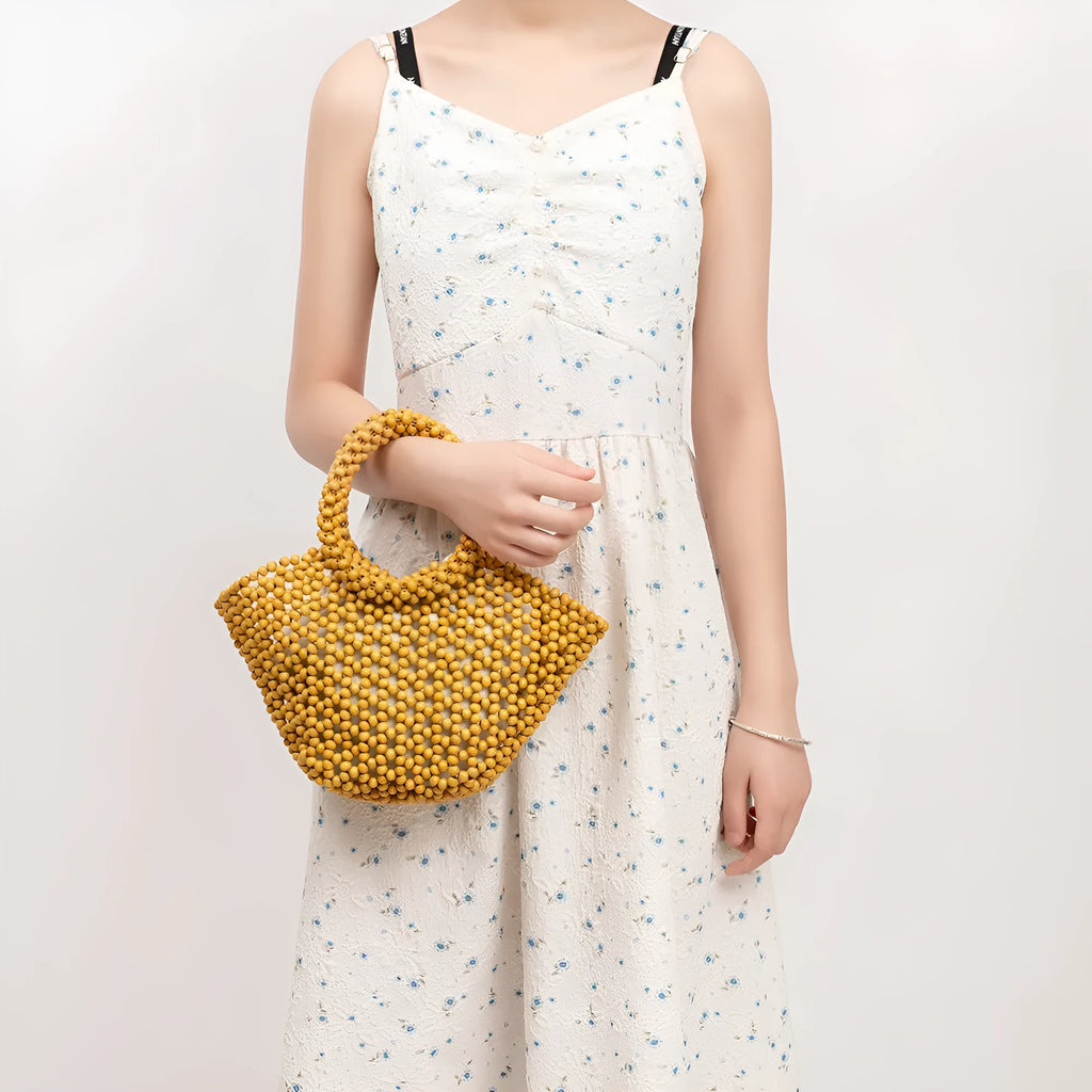 Hand-woven dumpling-shaped handbag with wooden beads in milky white colour