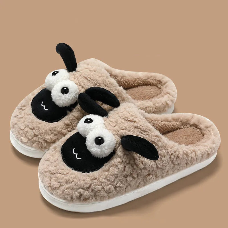Brown suede slip-on slippers with a sewn PVC sole on a wooden floor.