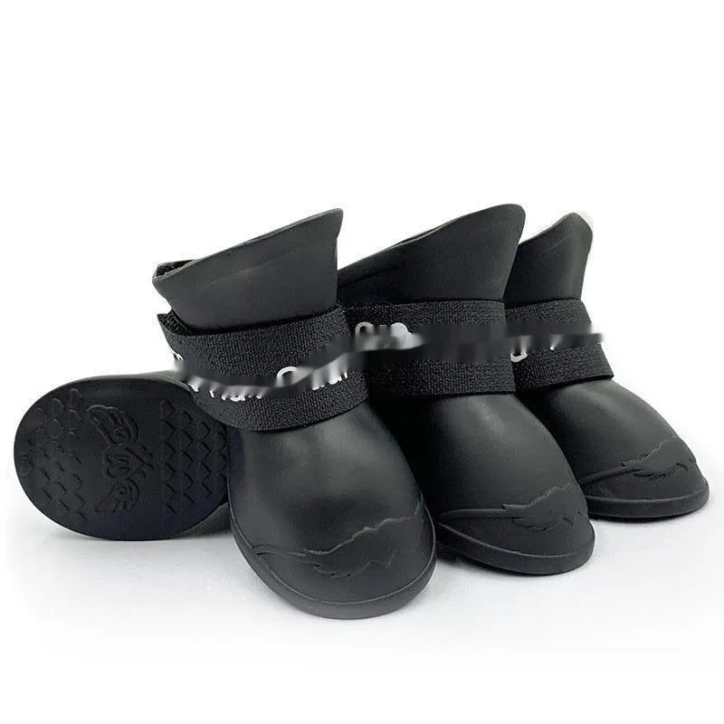 Set of four soft-soled rubber pet rain shoes in assorted colours on a grey background.