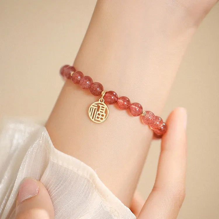 A New Chinese style glass bracelet with strawberry quartz stones and a blessing card.