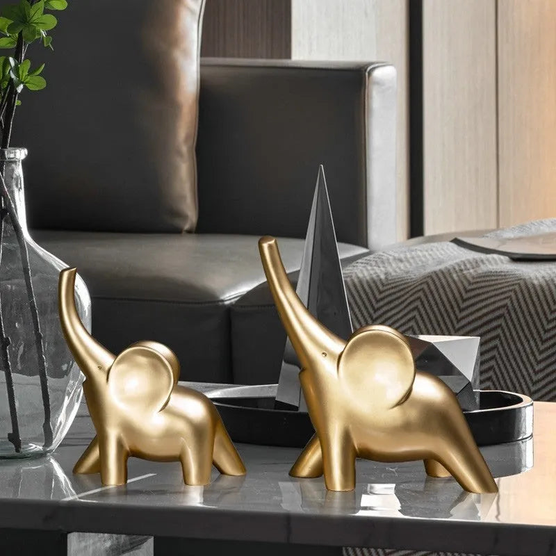 Modern resin elephant ornament in rose gold colour with raised trunk on display surface