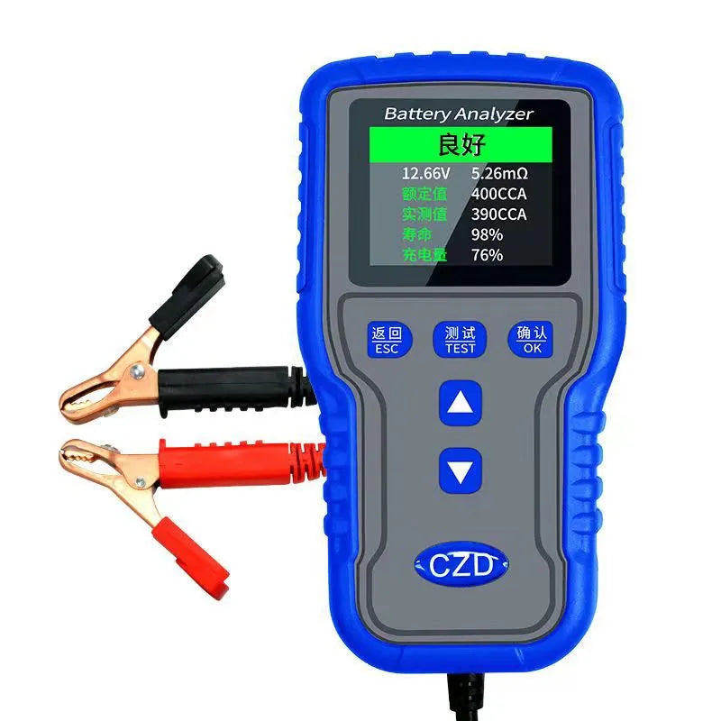 TKM016 car battery tester on a workbench, showing its compact 167x86x32mm size and handheld design