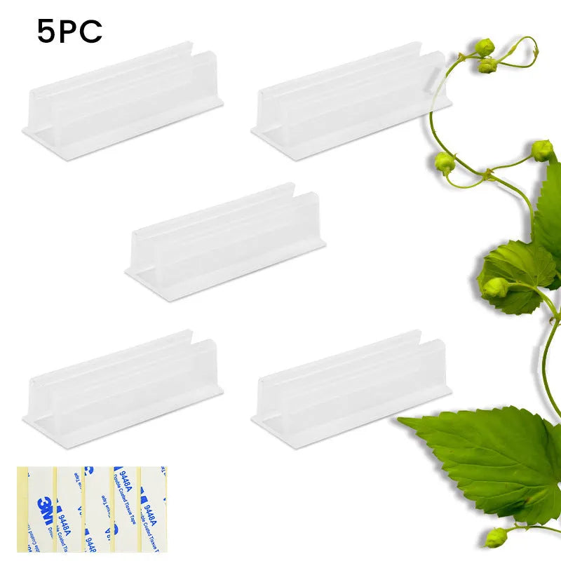Set of sticky plastic wall-mounted brackets holding data cables on a white wall in a bedroom