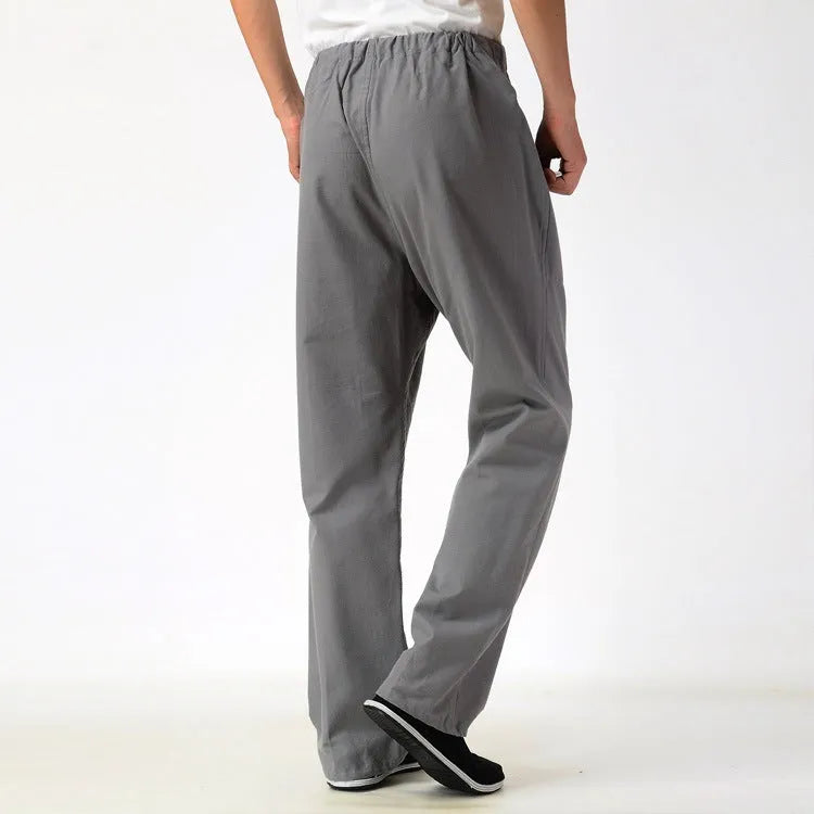 Man wearing beige pure cotton casual trousers with a drawstring waist and belt.